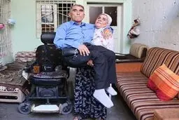 زنی که شوهر فلج خود را 10 سال روی پشت خود حمل می کند+ عکس