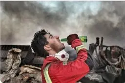 عکس حاشیه‌ساز از یک ‌آتش‌نشان در حمله به تهران | واکنش جالب یک آتش نشان به آگهی تبلیغاتی