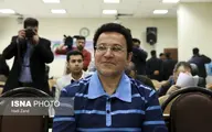 حسین هدایتی با دستبند و ماسک در راهرو دادگاه کیفری تهران