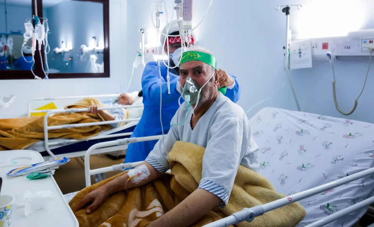  بیمارستان امیرالمومنین قم پر از بیماران کرونایی است |  بستن سربند به سر بیماران توسط طلاب +عکس